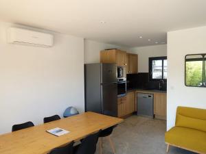 a kitchen with a wooden table and a refrigerator at Apartment Villa Kalliste by Interhome in Favone +24 photos