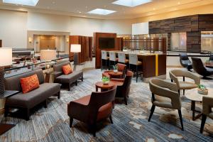 a lobby with a waiting area with chairs and tables at Marriott Birmingham Grandview in Birmingham