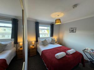 1 dormitorio con 2 camas y manta roja en The Carpenters Arms Rooms in Broadway, Laugharne, en Laugharne