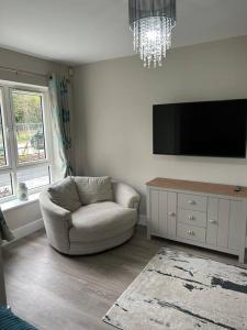 uma sala de estar com uma cadeira e uma televisão de ecrã plano em Meadow View em Alfreton