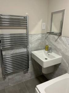 La salle de bains est pourvue d'un lavabo blanc et d'un miroir. dans l'établissement Meadow View, à Alfreton