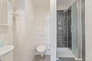 ein Bad mit einer Dusche, einem WC und einem Waschbecken in der Unterkunft BH01 Arbeiter Unterkunft für 10 Personen - 5 Doppelzimmer und vollausgestattete Küche in Neuhausen auf den Fildern