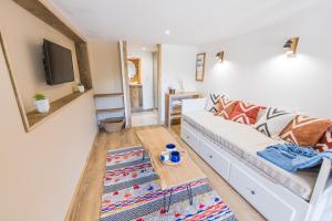 ein Wohnzimmer mit einem weißen Sofa und einem Couchtisch in der Unterkunft Le Milan Royal - Montmin in Montmin