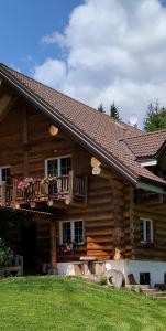 una baita di tronchi con balcone sul lato. di Chalet le Dorf a Nötsch