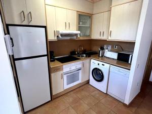 a kitchen with a white refrigerator and a dishwasher at Dreamsville Fuerteventura a 5 minutos de Lajares in Lajares