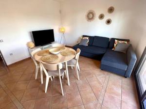 sala de estar con mesa y sofá azul en Dreamsville Fuerteventura a 5 minutos de Lajares, en Lajares