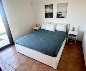1 dormitorio con 1 cama con 2 mesitas de noche y 2 mesas en Dreamsville Fuerteventura a 5 minutos de Lajares en Lajares