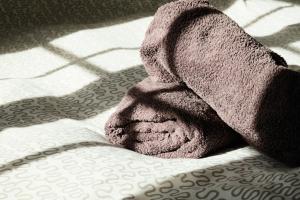 a towel sitting on top of a bed at Location Au Pied Du Vercors in Vinay +15 photos