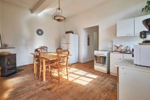 een keuken met een tafel en stoelen en een koelkast bij Location Au Pied Du Vercors in Vinay