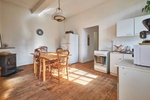 a kitchen with a table and chairs and a refrigerator at Location Au Pied Du Vercors in Vinay
