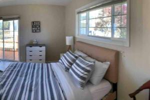1 dormitorio con cama con almohadas y ventana en Redwood Coast Beach Front Home California, en Smith River