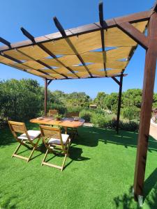 a wooden table and chairs under a wooden pergola at Pater Meus Suites in Cefalù