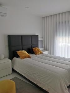 1 dormitorio con 1 cama grande con almohadas amarillas en Vila Amares, en Amares