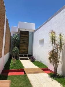 um edifício branco com uma porta e algumas palmeiras em Loft em Guaratinguetá - SP em Guaratinguetá