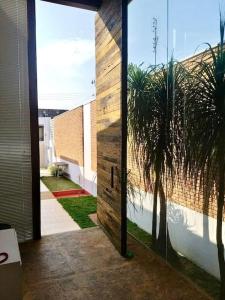 uma porta para um edifício com uma palmeira no exterior em Loft em Guaratinguetá - SP em Guaratinguetá