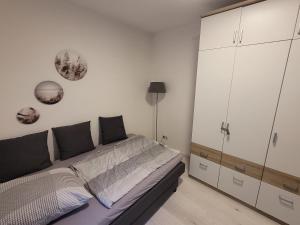a bedroom with a bed and a large white cabinet at Souterrainwohnung in Viernheim +8 photos