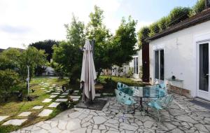 een patio met een glazen tafel en een parasol bij Chambres d'hôtes Vue sur la Muraille de Sens in Sens
