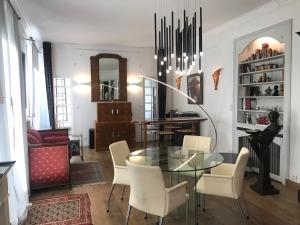 une salle à manger avec une table en verre et des chaises blanches dans l'établissement Chambres d'hôtes Vue sur la Muraille de Sens, à Sens