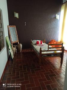 sypialnia z łóżkiem i krzesłem w pokoju w obiekcie Chácara ADLUC w mieście Cascavel