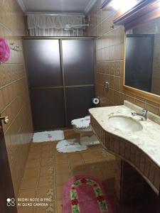 a bathroom with a sink and a shower at Chácara ADLUC in Cascavel