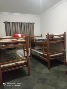 a room with three bunk beds in a room at Chácara ADLUC in Cascavel