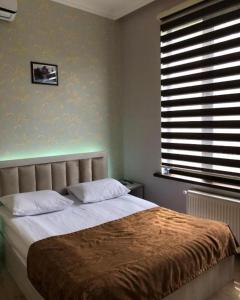 Schlafzimmer mit einem großen Bett und einem Fenster in der Unterkunft HOTEL MRT in Mingəçevir