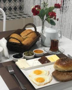 einen Tisch mit einem Teller Brot und Eiern darauf in der Unterkunft HOTEL MRT in Mingəçevir