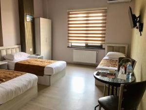1 dormitorio con 2 camas, mesa y ventana en HOTEL MRT en Mingachevir
