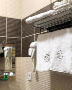 ein Badezimmer mit weißen Handtüchern auf einem Handtuchhalter in der Unterkunft HOTEL MRT in Mingəçevir