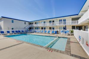 a pool with chairs and chairs in front of a hotel at Wildwood Crest Condo Rental Walk to Beach! in Wildwood Crest