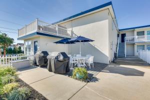 a patio with a table and an umbrella in front of a house at Wildwood Crest Condo Rental Walk to Beach! in Wildwood Crest