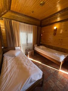 two beds in a room with wooden walls at Хостел 24 in Khmelʼnytsʼkyy