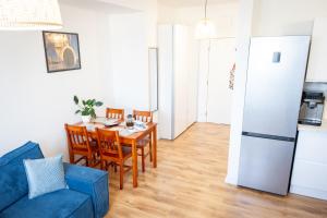 kuchnia i jadalnia ze stołem i niebieską kanapą w obiekcie Apartament Kapitan w Świnoujściu