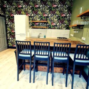 a kitchen with a table with four chairs and a sink at The Queen Street Bunkhouse in Newcastle upon Tyne
