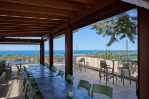 a patio with tables and chairs and a view of the ocean at Verde - Euroappartamenti in San Vincenzo