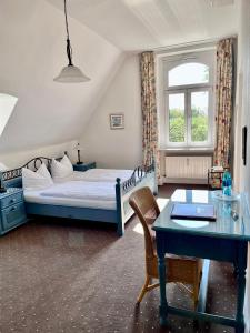 - une chambre avec un lit, un bureau et une table dans l'établissement Villa Sophienhöhe, à Kerpen
