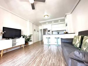 uma sala de estar com um sofá e uma cozinha em Arenales del Sol Beach Apartment em Arenales del Sol