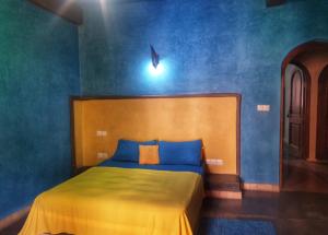 a bedroom with a bed with a blue wall at Atlas Tigmi in Ourika