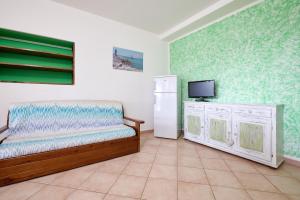 Schlafzimmer mit einem Bett, einem TV und einem Kühlschrank in der Unterkunft Verde - Euroappartamenti in San Vincenzo