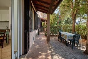 a patio with a table and chairs on a house at Verde - Euroappartamenti in San Vincenzo