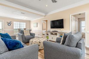 ドーフィン・アイランドにあるMalibu Beach House IIのソファと薄型テレビのあるリビングルーム