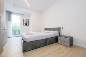 a bedroom with a large bed in a white room at BergamoCityCenter 02 in Bergamo