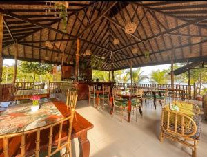 a restaurant with wooden tables and chairs and a large ceiling at La Tranquilidad Beach Club 