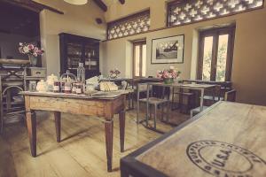 a dining room with tables and chairs and flowers at Relais di charme Frazione Chiavolino in Pollone