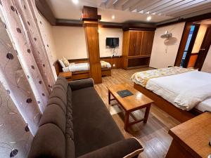 Habitación de hotel con sofá y cama en Hotel Gajraj en Gangtok