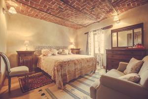 a bedroom with a bed and a couch and a chair at Relais di charme Frazione Chiavolino in Pollone