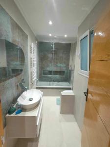 a bathroom with a sink and a bath tub at Dar Al Yaqout in Al Karm