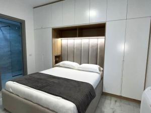 a bedroom with a large bed and white cabinets at Diamond DREAM in Sarandë +78 photos