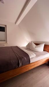 1 dormitorio con 1 cama grande con sábanas blancas en Ferienwohnungen Hexenstieg & Wurmbergblick, en Schierke