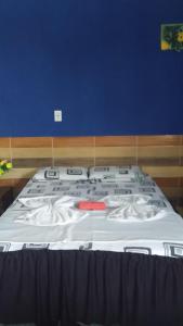 uma cama grande num quarto com uma parede azul em pousada chykos em Barreirinhas